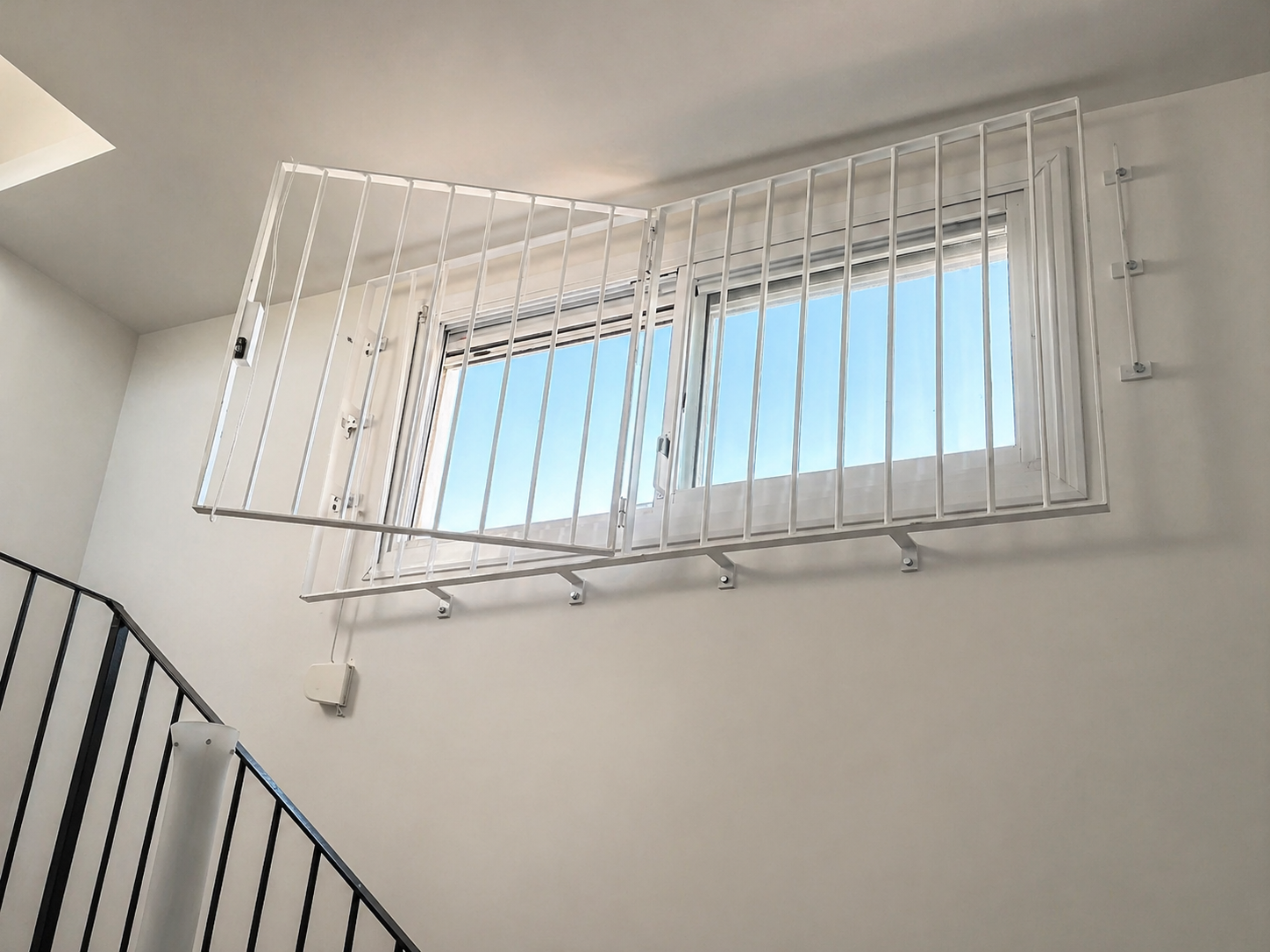 Reja metálica abatible instalada en ventana interior de vivienda